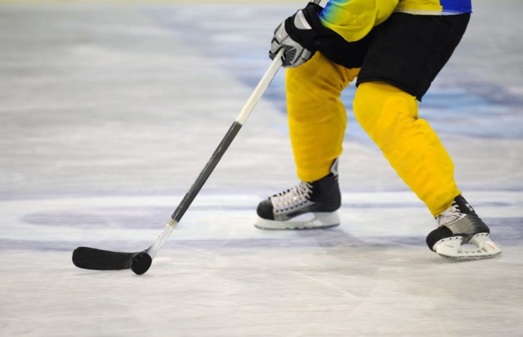 An ice hockey player controlling the puck on his stick