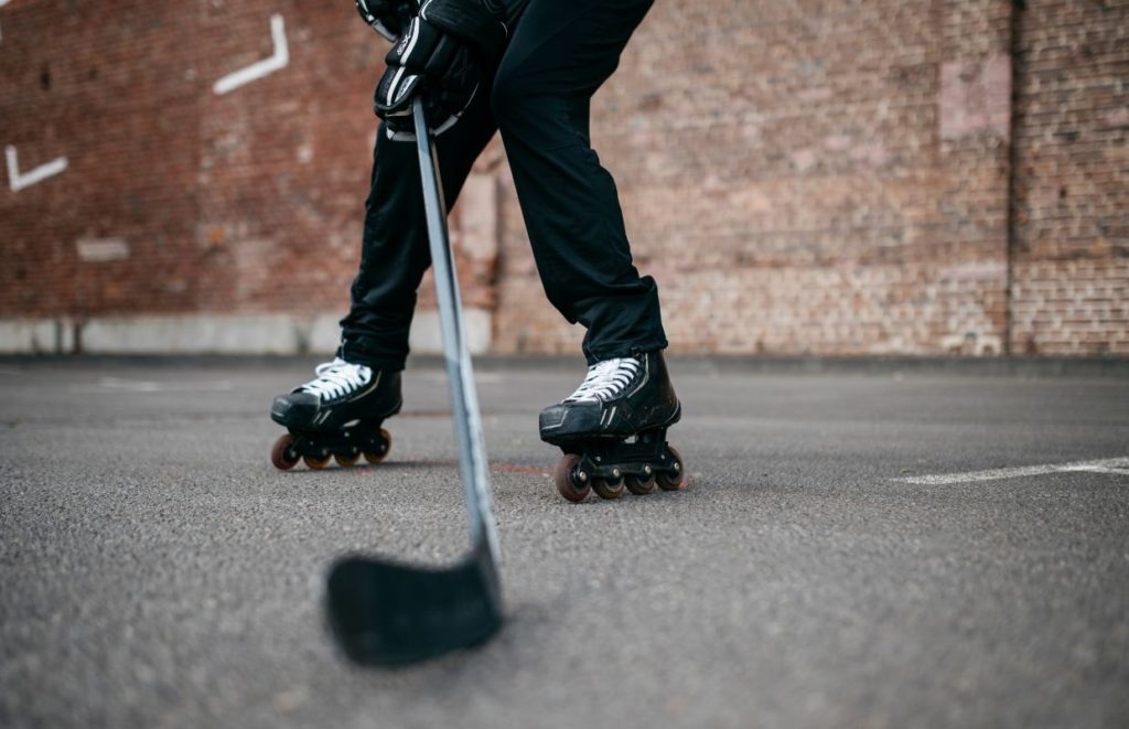 A person on in-line skates with a roller hockey stick